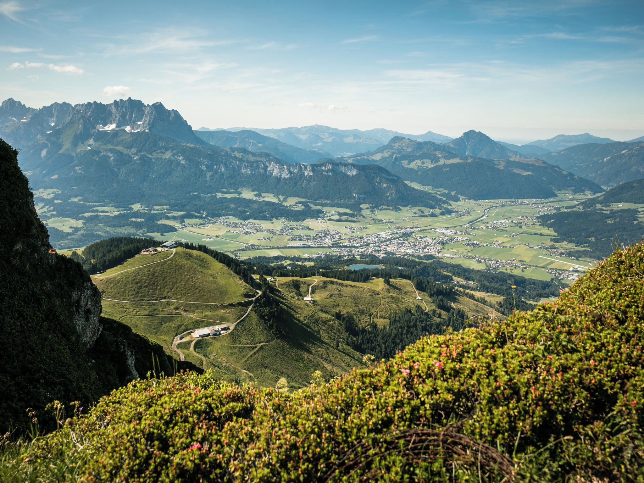 Een bergachtig landschap met een vallei, wegen en een kleine nederzetting.