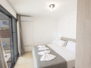 A hotel room with a bed, a window with curtains, a ceiling light, and a view of the outside. - Ferienvilla für 10 Personen in Protaras by Interhome (Protaras)