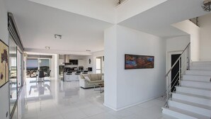 Ambienti spaziosi e moderni con cucina, zona soggiorno e scala.