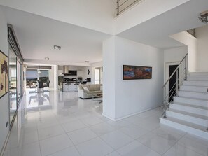 A spacious, modern interior with a kitchen, living area, and staircase. - Moderne 3-Schlafzimmer-Villa mit atemberaubendem Meerblick by Interhome (Protaras)