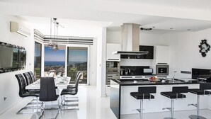 Una cucina moderna con zona pranzo, ampie finestre e vista sul paesaggio.