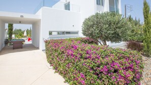 A modern white building with a balcony, surrounded by vibrant purple flowers and green shrubs. - Protaras Greco Villa CCV1 mit beheiztem Pool by Interhome (Paralimni)