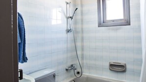 Ein Badezimmer mit Toilette, Waschbecken, Badewanne und Dusche.