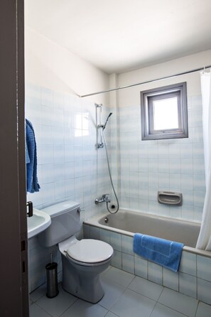 Ein Badezimmer mit Toilette, Waschbecken, Badewanne und Dusche.