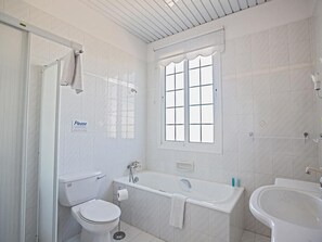 Moderni kylpyhuone, jossa on wc, kylpyamme ja pesuallas.