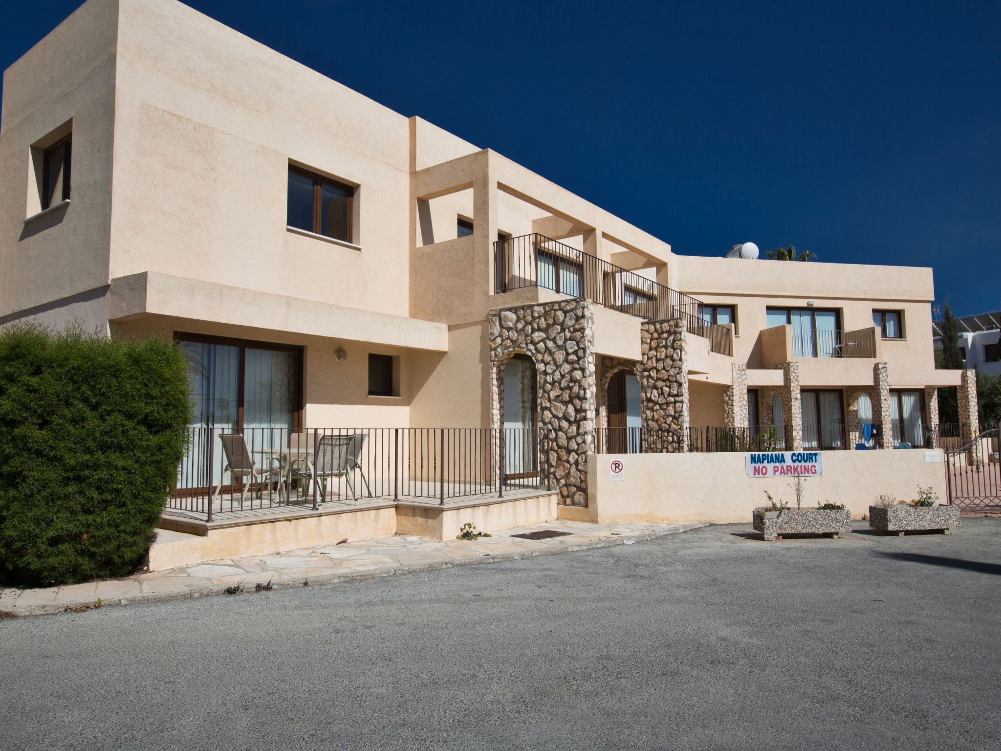 A modern building with a sign reading "NAPIANA COURT NO PARKING".