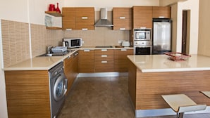 Eine moderne Küche mit Holzausstattung, Edelstahlgeräten und einer integrierten Waschmaschine.