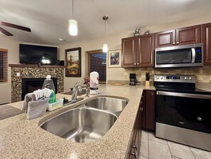 A modern kitchen with granite countertops, stainless steel appliances, and wooden cabinets.