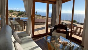 A spacious room with a large glass table, comfortable seating, and a view of the ocean. - Romantische Ferienvilla mit Infinity-Pool und Panoramameerblick by Interhome (Puntagorda)
