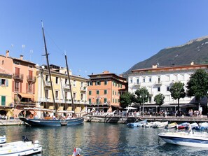 Ein Hotel am Wasser mit mehreren Etagen, Balkonen und einem Steg mit Booten.