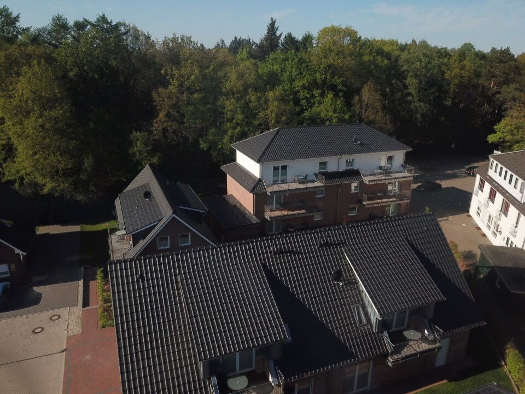 A residential area with multiple houses, some with sloped roofs and others with flat roofs.