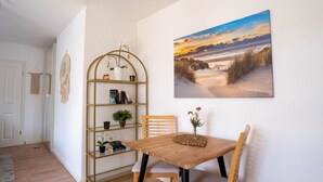 A room with a wooden table and chairs, a bookshelf, a framed picture on the wall, and a door. - Schule Altes Land by Interhome (Jork)