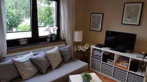 A living room with a sofa, TV, and a small table with a plant. - Apartment Oliver by Interhome (Fritzlar)