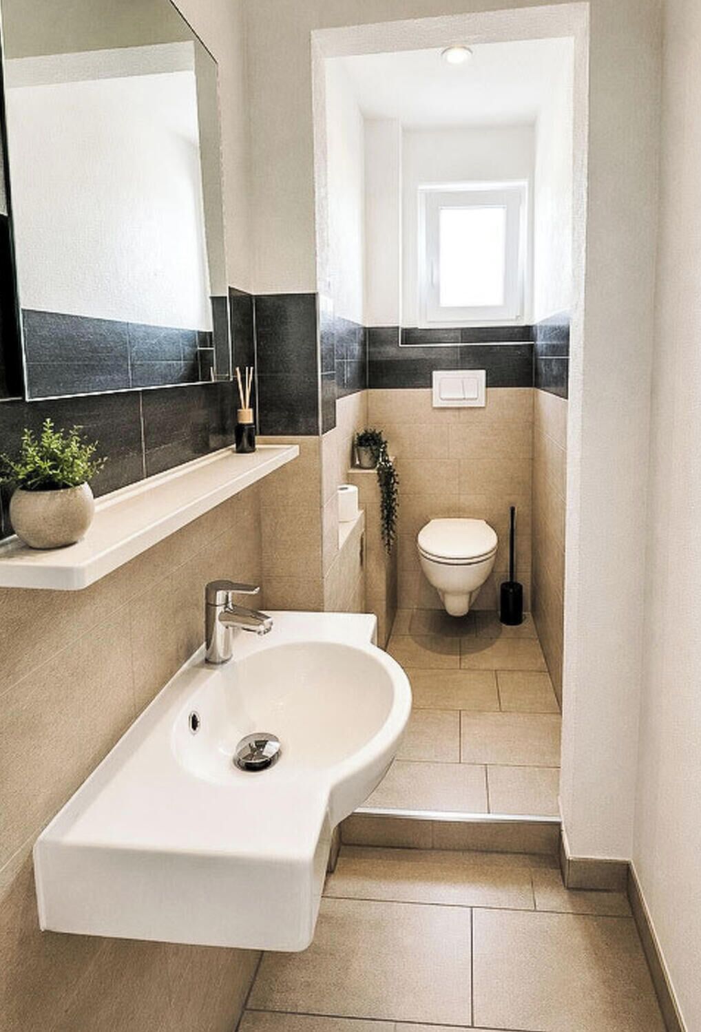 A modern bathroom with a white sink, a mirror, and a toilet.