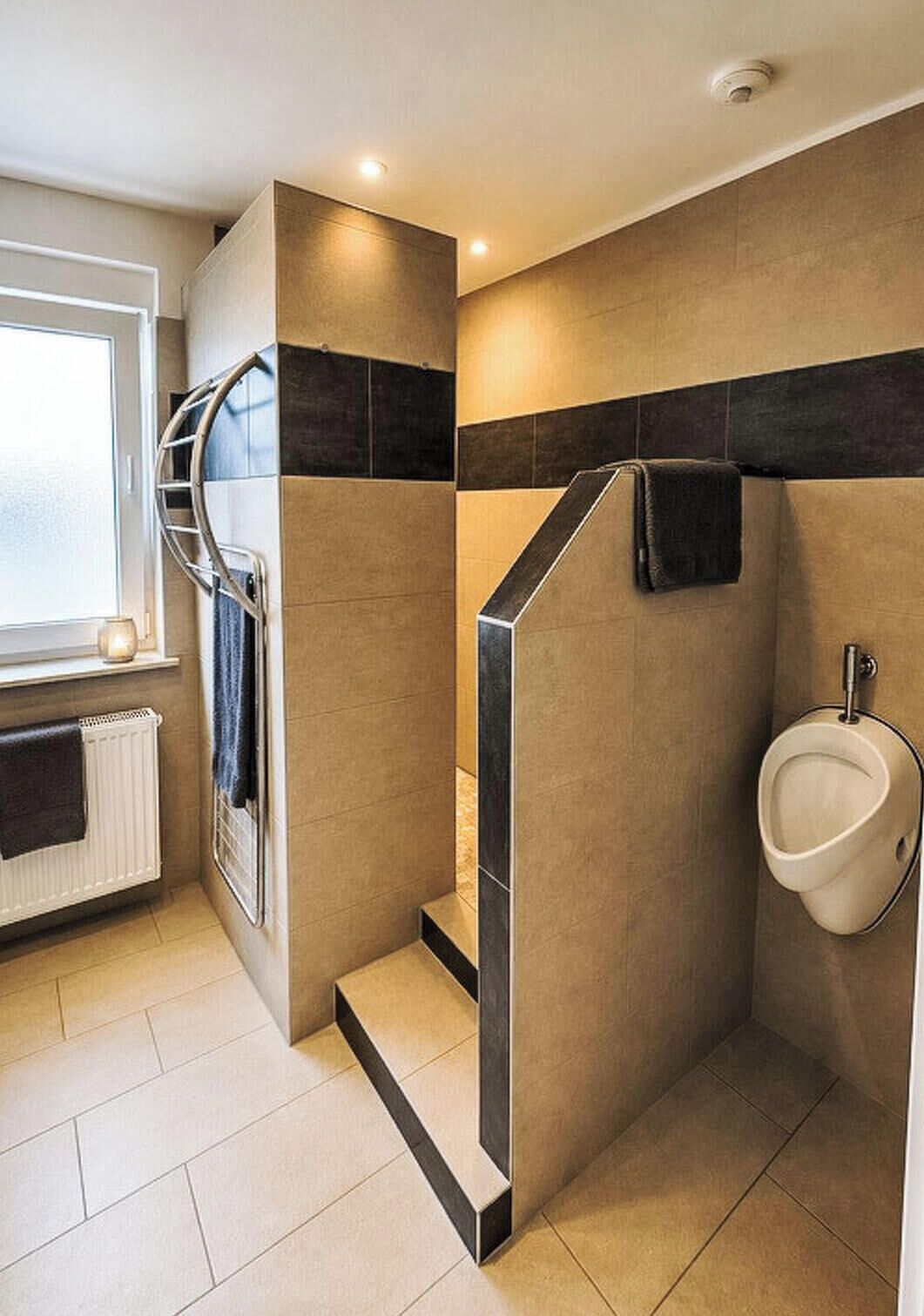 Un baño moderno con ducha, inodoro y toallero.