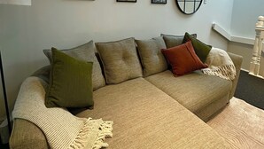 Una sala de estar con un sofá, una lámpara y tres cuadros en la pared.