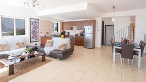 Un appartamento moderno con soggiorno, zona pranzo, cucina e una scala che conduce a un piano superiore.