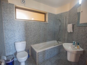 Ein Badezimmer mit Toilette, Badewanne und Waschbecken.