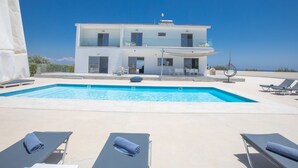 A modern two-story building with a swimming pool and sun loungers. - Geräumiges Ferienhaus für 12 Personen in Paralini by Interhome (Paralimni)
