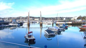 A marina with various boats docked, calm water, and a distant cityscape. - Helle Wohnung in Torquay mit Garten by Interhome (Torquay)