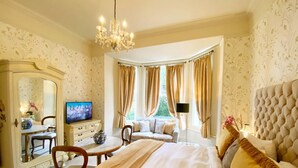 A bedroom with a large bed, a television, a dresser, and a window with curtains. - Helle Wohnung in Torquay mit Garten by Interhome (Torquay)