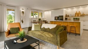 Una sala de estar moderna con un sofá, una mesa de centro y un comedor con una mesa y sillas.