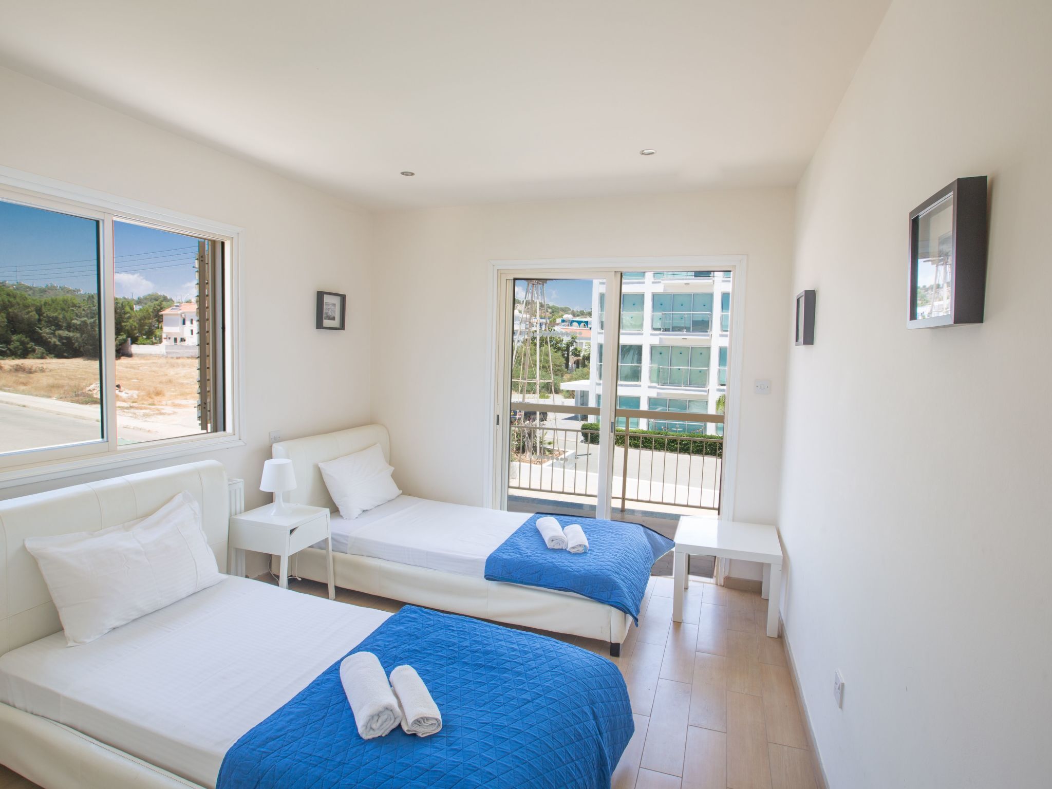 Habitación de hotel con dos camas, un balcón y vista al mar.