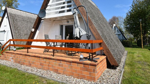A triangular-shaped building with a brick patio and outdoor seating area. - Carolin by Interhome (Baabe)