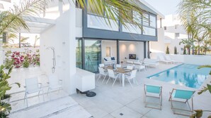 A modern two-story house with a swimming pool, outdoor seating, and lush greenery. - Neue, moderne 3-Schlafzimmer-Villa mit privatem Pool by Interhome (Paralimni)