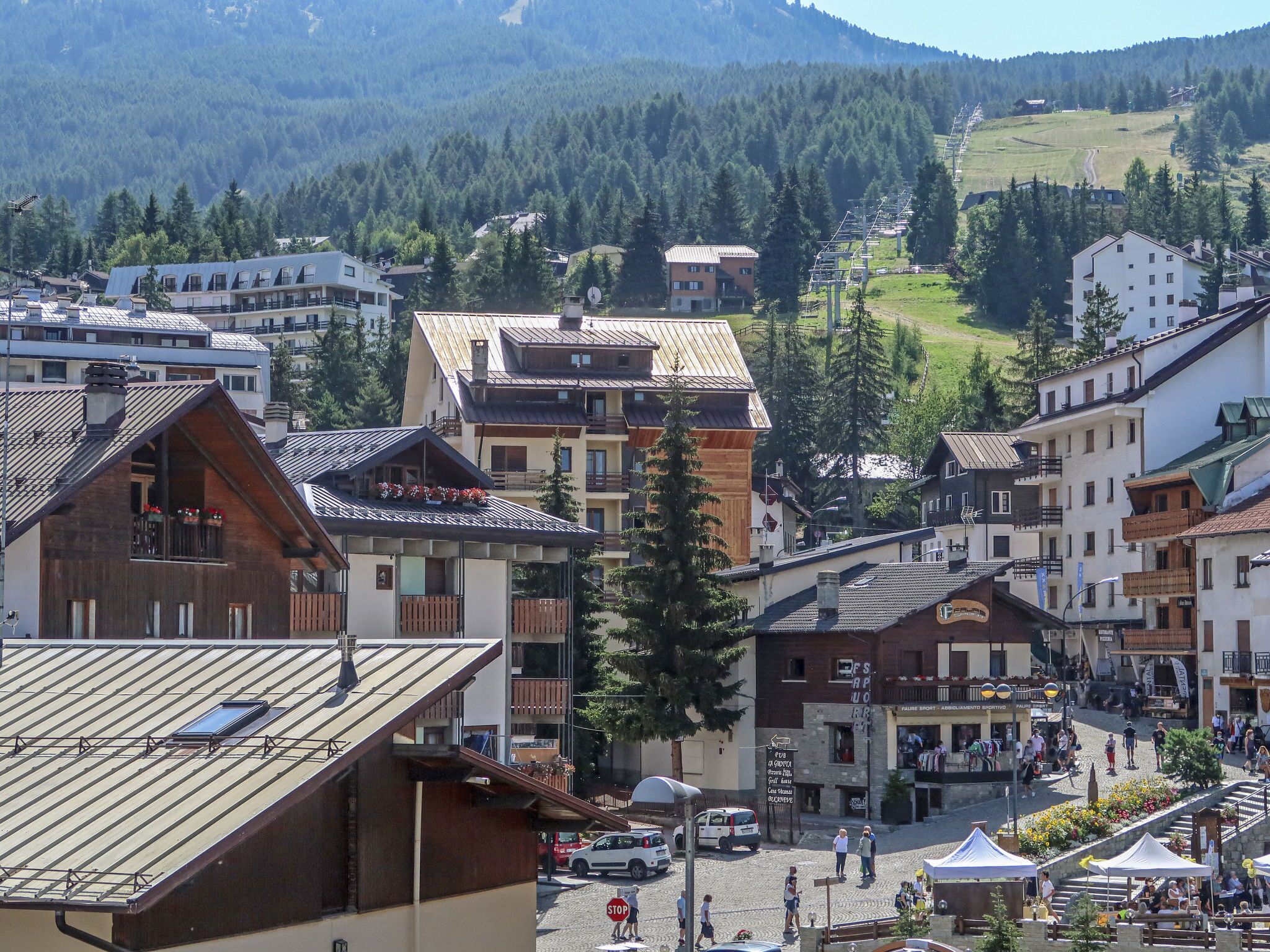 Une ville à l’architecture traditionnelle, avec des bâtiments en bois et une place centrale où se trouvent des cafés et des terrasses.