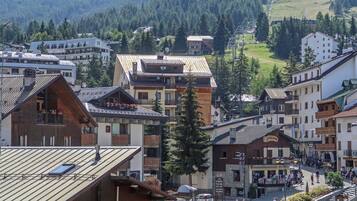 Une ville à l’architecture traditionnelle, avec des bâtiments en bois et une place centrale où se trouvent des cafés et des terrasses.