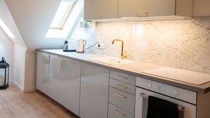 A modern kitchen with a skylight, a built-in oven, and a marble backsplash. - Schule Altes Land by Interhome (Jork)