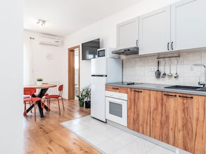 Eine moderne Küche mit weißen Schränken, einer Holz Arbeitsplatte und einem eingebauten Backofen.