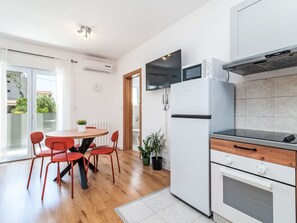 Eine moderne Küche mit Essbereich, ausgestattet mit integriertem Mikrowellenherd, Backofen und einem Flachbildfernseher.