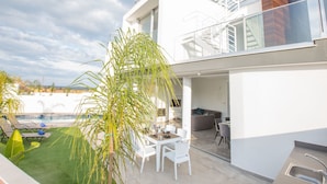 Una casa moderna de dos pisos con balcón, comedor y piscina.