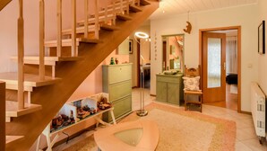 Eine Treppe führt zu einem Schlafzimmer mit einem Bett, einem Schminktisch und einem Spiegel.
