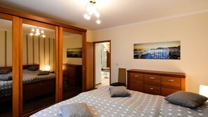 Ein Schlafzimmer mit einem Bett, einem Schminktisch, einem Spiegel und einem Bild an der Wand.