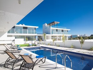 A modern pool area with lounge chairs and a clear blue sky. - Atemberaubende Villa Olivine mit Meerblick by Interhome (Protaras)