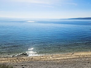 Una playa con agua cristalina y orilla pedregosa.