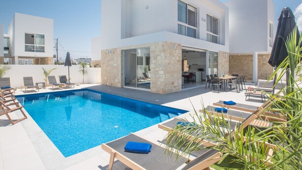 A modern two-story house with a swimming pool, outdoor seating, and a stone facade. - Protaras Vie Bleu Villa mit Pool, im Zentrum by Interhome (Protaras)