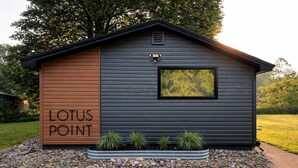 En lille bygning med et skilt, der siger 'LOTUS POINT', og et vindue med udsigt til træer.