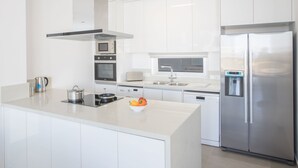 A modern kitchen with white cabinetry, stainless steel appliances, and a central island. - Schöne Villa Olivine Pearl OL5 mit Garten by Interhome (Protaras)