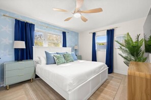 A bedroom with a bed, nightstands, a ceiling fan, and a window with curtains. - Luxury 5BR  Heated Pool, Pickleball & Hot Tub (Seminole)
