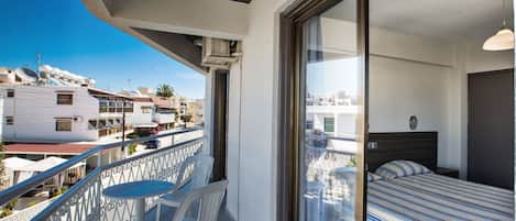 Un balcón con cama, una mesa y dos sillas.