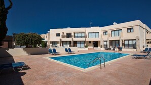 A hotel with a swimming pool, multiple balconies, and a paved patio area. - Moderne Erdgeschosswohnung in Ayia Napa by Interhome (Ayia Napa)