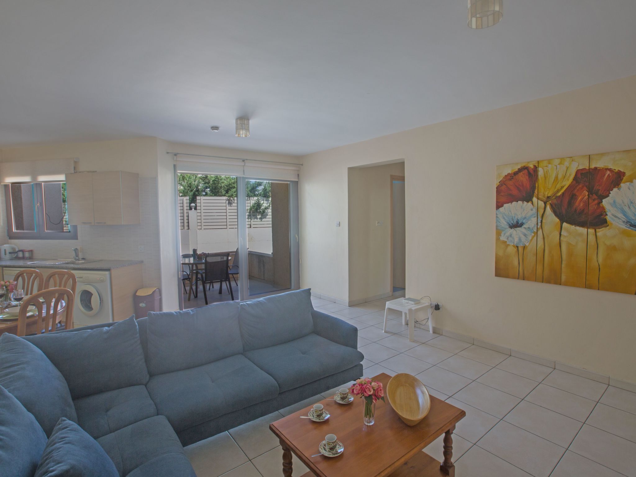 Una sala de estar con un sofá, una mesa de centro y un cuadro en la pared.