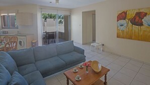 A living room with a sofa, a coffee table, and a painting on the wall. - Moderne Erdgeschosswohnung in Ayia Napa by Interhome (Ayia Napa)