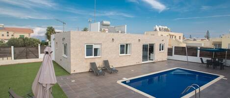 A rooftop pool area with a swimming pool, lounge chairs, and a covered seating area.