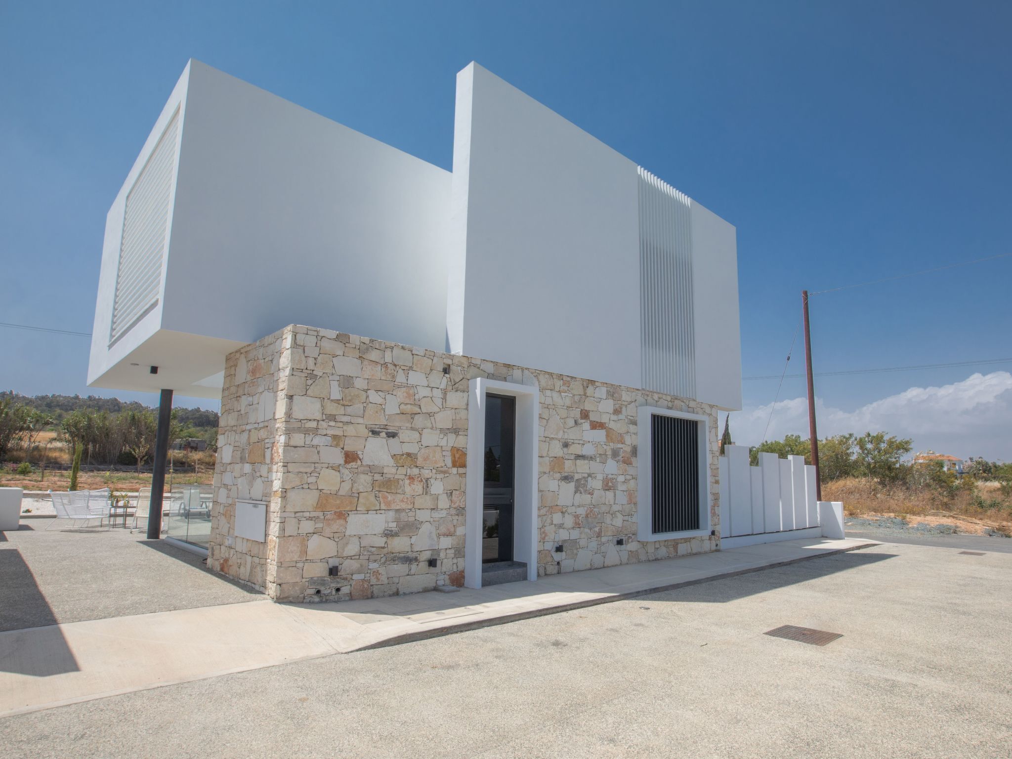 Un edificio moderno con facciata in pietra e una grande struttura bianca adiacente.
