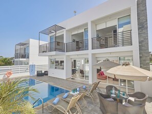 Ein modernes, zweistöckiges Gebäude mit Schwimmbad, Außenbereich und Balkon.